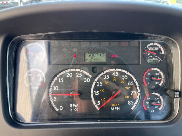 Dashboard of a 2015 Freightliner M2 showing gauges and digital readout; speedometer in mph, tachometer x100, engine panels, and various indicator gauges.