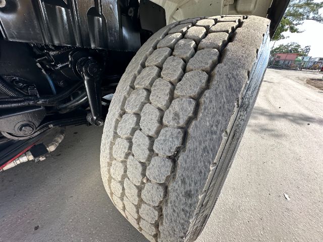 Truck tire close-up on International 7500 vacuum truck showing heavy tread blocks and wheel well.