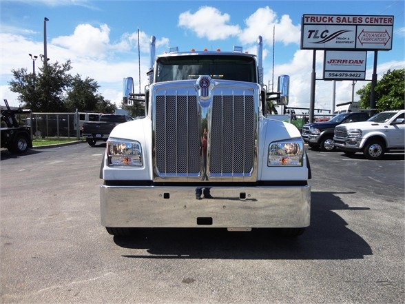Front view of a 2022 Kenworth W900 truck with chrome grille, bumper, and large headlights in a dealership lot.