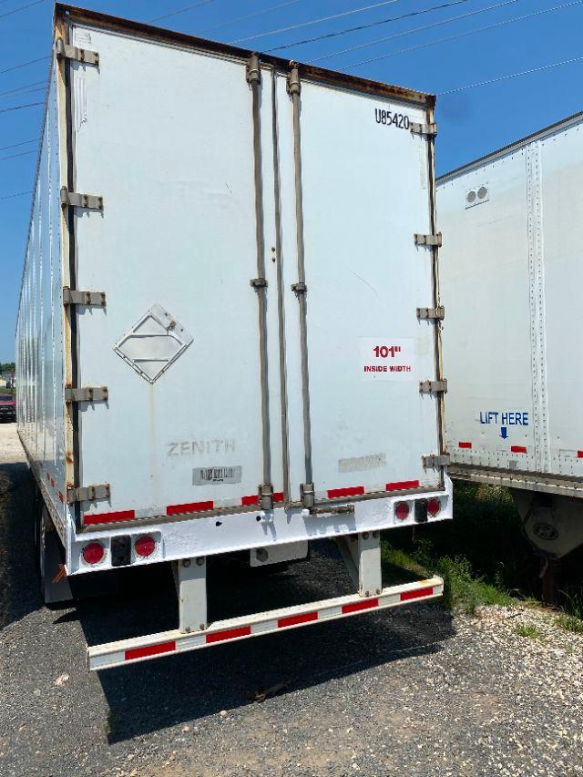 Rear view of a white Wabash Duraplate trailer with double doors, metal hinges, and red rear bumper reflectors. Markings include '101" INSIDE WIDTH' and 'ZENITH' with a diamond placard.