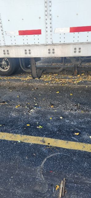 2014 Wabash dry van trailer side with white aluminum panel and red reflective markings; black asphalt with a yellow line.