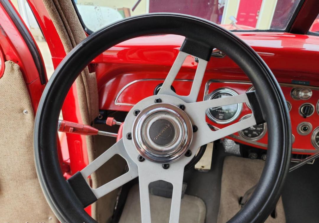 Diamond T hauler truck interior showing steering wheel with 'Diamond' center cap and red dashboard with gauges.