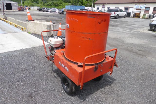Orange Agri-Metal CA8064 portable mixer or auger on a small trailer with a cylindrical body and white engine, in an outdoor lot