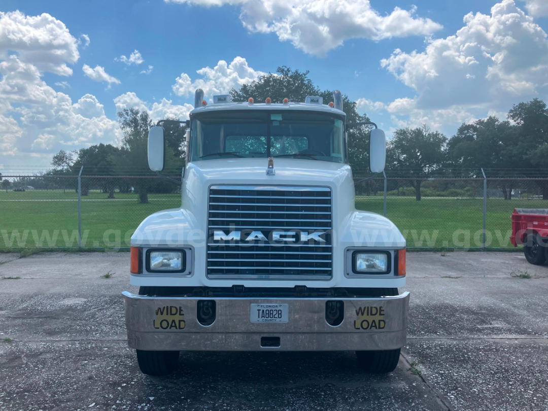 Front view of a white 2006 Mack CHN613 cab and chassis truck with chrome bumper, large grille, dual mirrors, and 'WIDE LOAD' markings on bumper.
