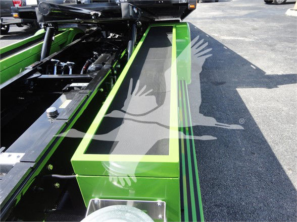 Green Peterbilt 337 truck frame with hydraulic components and black carbon fiber panels; visible text not legible