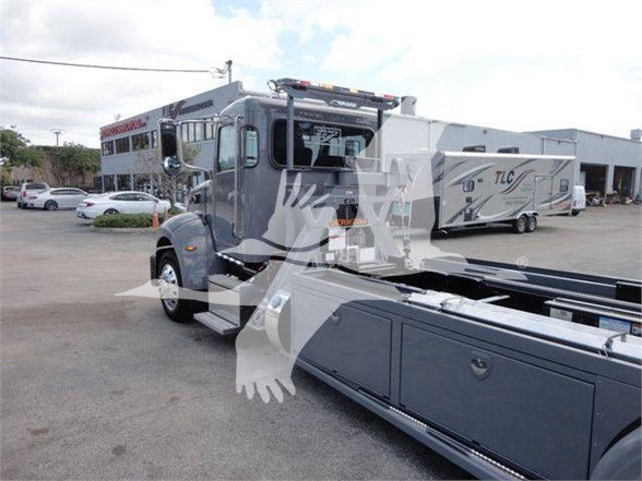 2022 Peterbilt 337 tow truck front-left view with extended cab and chassis in a dealership lot.
