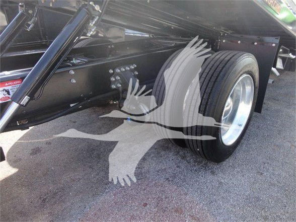 Truck chassis and single rear axle with dual-tire wheel, undercarriage and suspension components visible.