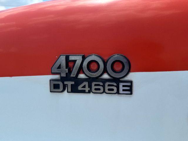 Tractor-trailer cab badge showing '4700 DT466E' on red and white paint.
