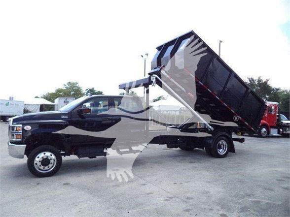 2023 International CV dump truck in service with the dump bed raised, black color with white tribal graphics on cab and black dump box.