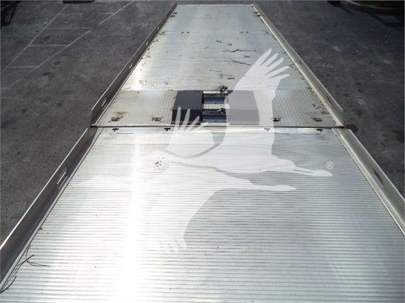 Tractor-trailer bed/flatbed area from a 2019 Kenworth T370 listing showing metal deck with tie-down slots and a small raised hatch.