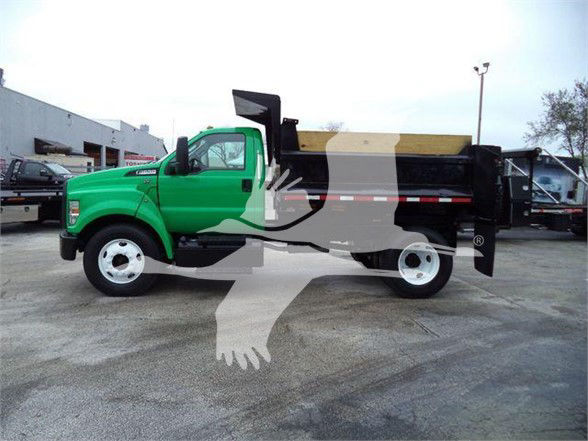 2017 Ford F650 SD dump truck green cab with black dump bed, showing side profile.