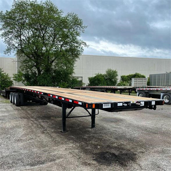 Flatbed trailer showing a long wood deck with extendable mechanism and multiple axles undercarriage. Fontaine XCALIBUR extendable 53'-90' trailer.