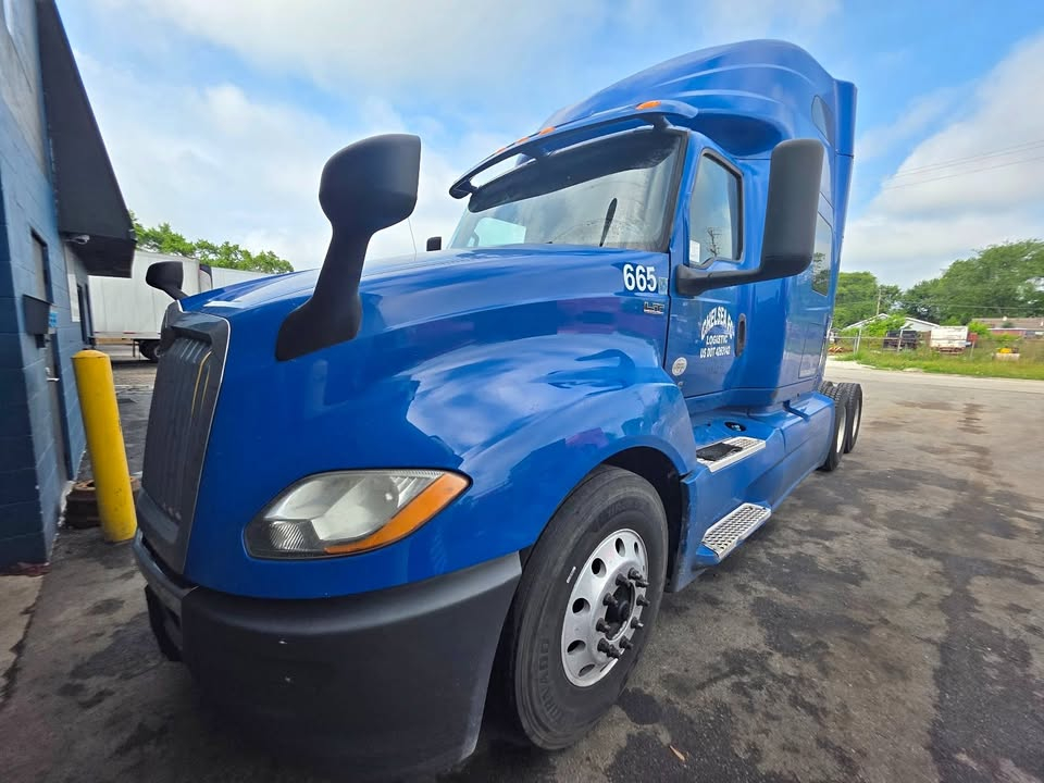 Blue 2018 International LT truck with Cummins ISX engine and 10-speed transmission, stock number 665, side view showing front cab and driving area.