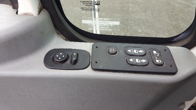 Interior window and control panel of a 2007 International 8600 daycab truck showing mirror and window with control switches.