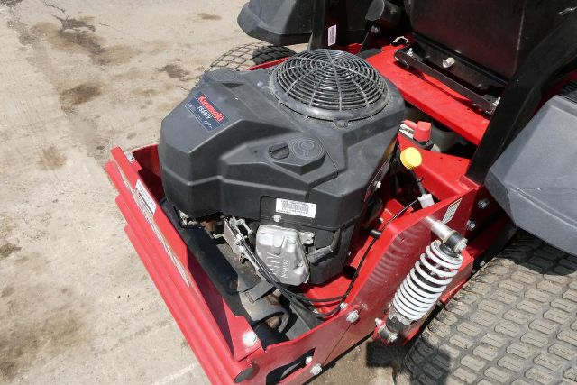 Ferris IS 700Z lawn tractor engine bay showing Briggs & Stratton/ Kawasaki style small gas engine with air filter cover and front suspension shocks