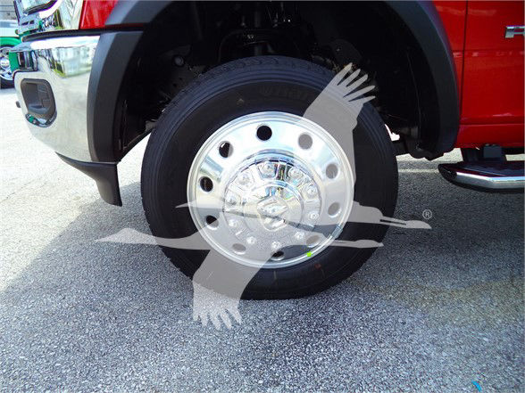 Ram 5500 SLT front wheel showing chrome hubcap and tire, part of a flatbed truck with red bodywork.