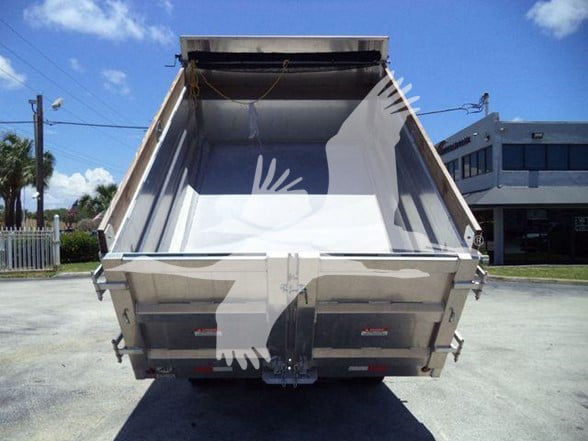 Isuzu NQR dump truck bed viewed from rear showing empty steel dump box with tailgate and hydraulic mechanism.