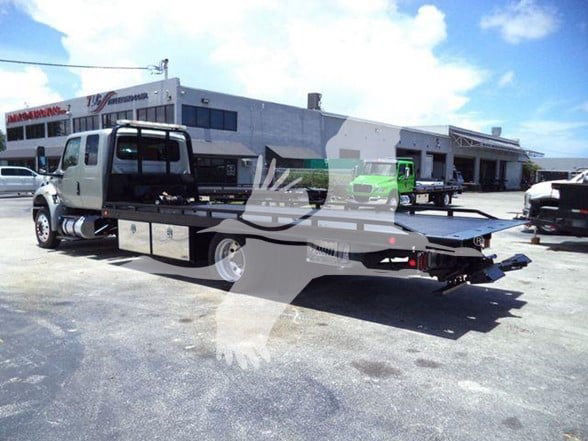 2022 International MV tow truck with flatbed, stock number T50307, visible in a dealership lot.