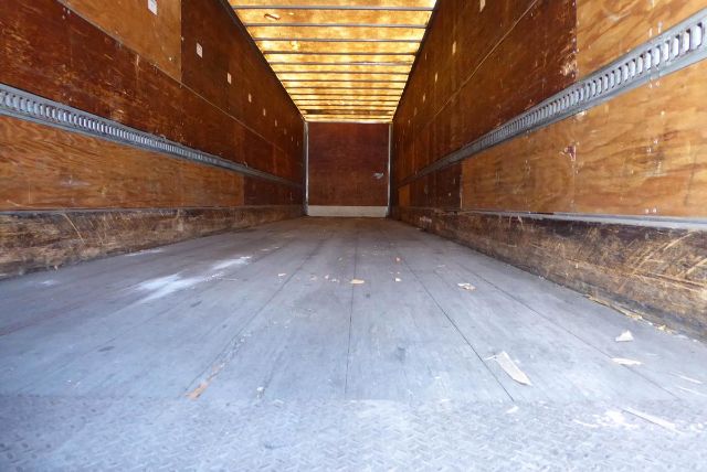 Trailer interior with wood side walls and a metal floor, empty cargo area.