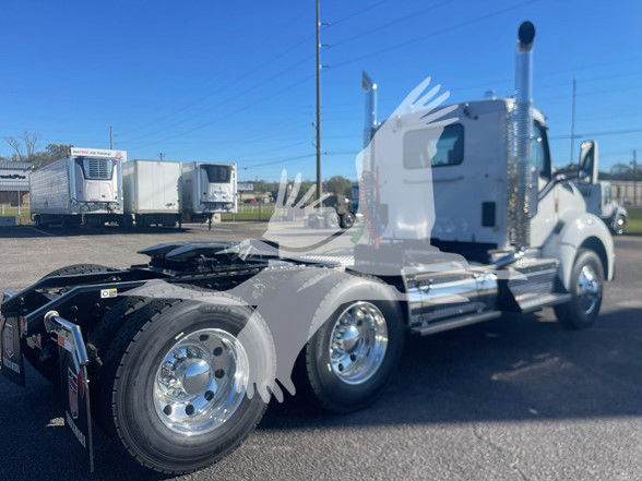 Kenworth T880 conventional daycab truck showing dual rear axles and chrome wheels with blue sky background.