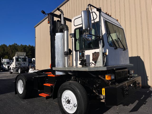 2013 Tico Prosper PROS POTTER DOT truck chassis with cab, side exhaust, and steps; white cab, black chassis, large tires, and yellow reflectors.