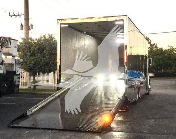 Peterbilt 337 tow truck trailer with ramp extended, rear view showing open cargo area and reflective surface.