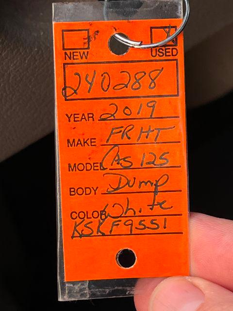 Orange tag with handwritten vehicle details: Year 2019, Make FRHT, Model Cascadia 125, Body Dump, Color KS F95S1?