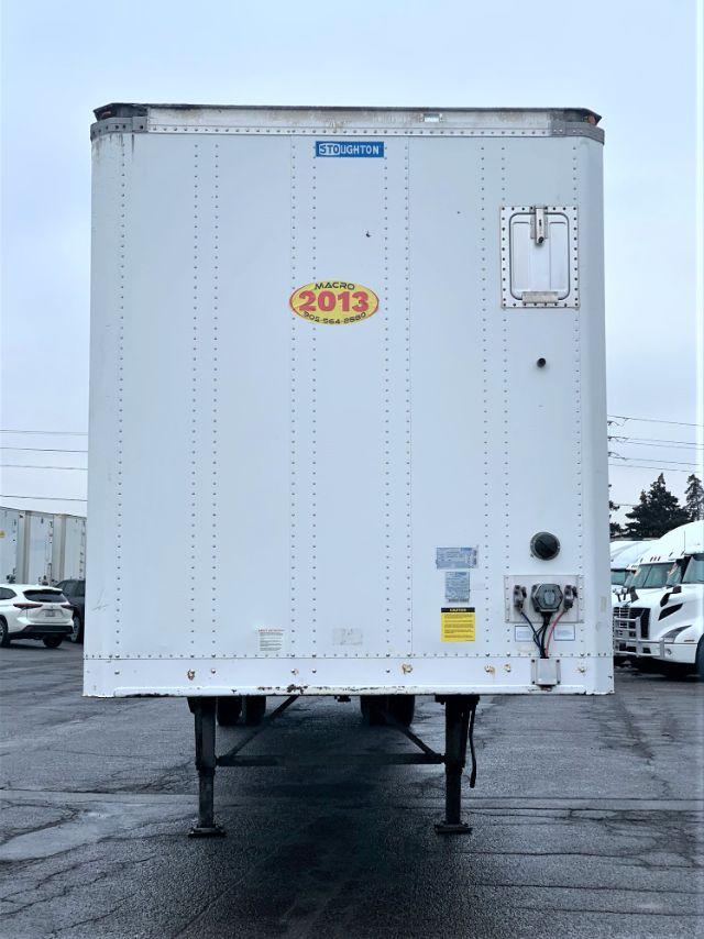 Stoughton dry van trailer rear view showing registration sticker and access door with landing pad and electrical/air connections.