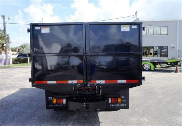 Isuzu NPR HD dump truck rear view showing dual-tone black dump bed with rear lights and hitch.