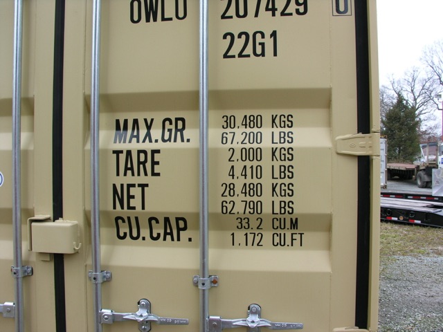 Container trailer door shows capacity labels: MAX. GR. TARE NET CU. CAP with numbers 30,480 KGS; 67,200 LBS; 2,000 KGS; 4,410 LBS; 28,480 KGS; 62,790 LBS; 33.2 CU.M; 1,172 CU.FT.