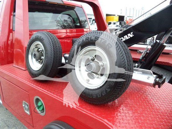Ram 4500 tow truck bed with two mounted tires on diamond plate surface.