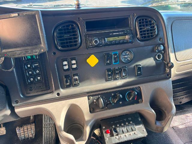 Dashboard of a 2016 Freightliner M2 106 with multiple switches, two circular air vents, radio, and control panel.