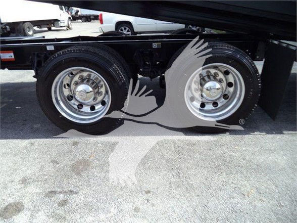 Kenworth T880 rear wheels and frame showing dual axles and polished metal rims with treaded tires.