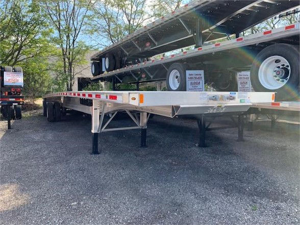 Flatbed trailer with 48-foot Fontaine all-aluminum trailer frame and dual tires, showing side rails and landing gear.