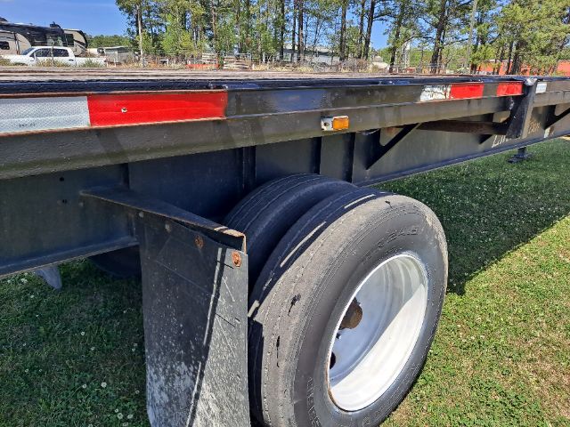 Fontaine flatbed trailer side view showing dual rear wheel and side railing.
