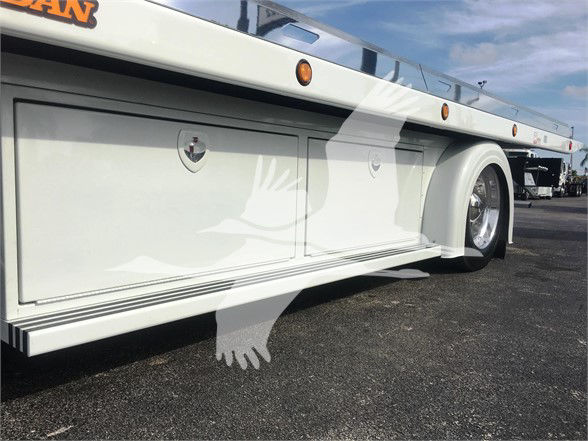 Peterbilt 337 flatbed truck side with storage compartments and wheel. Visible text includes 'MAN' partial logo on top left corner.