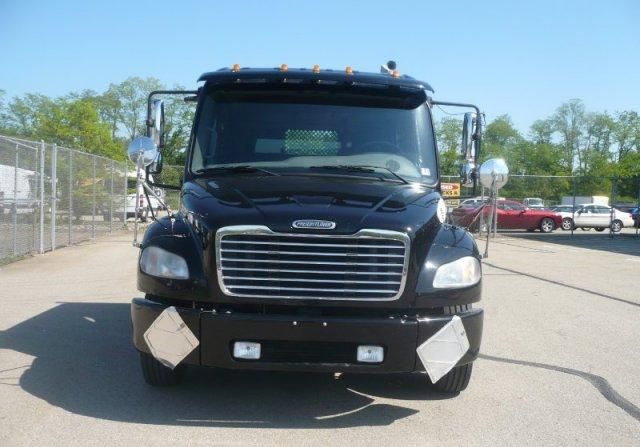Front view of a black 2007 Freightliner M2 daycab truck with chrome grille, large bumper, and two rectangular fog lights.