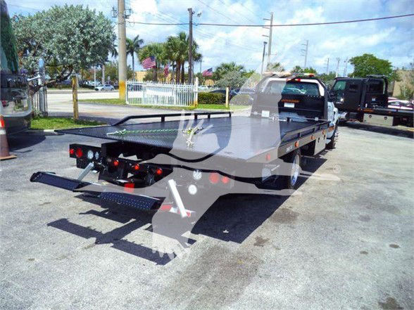 Tow truck flatbed with rear hydraulic system and ramps, Chevrolet Silverado 6500HD shown in image.