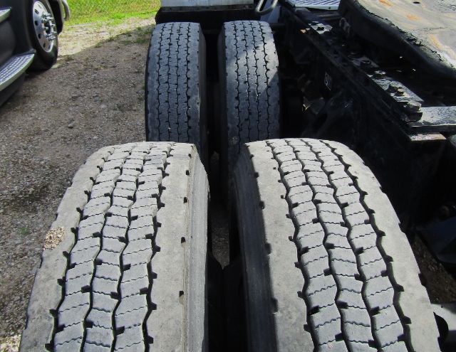 Kenworth truck rear dual tires and chassis showing tread pattern and wheel assemblies.