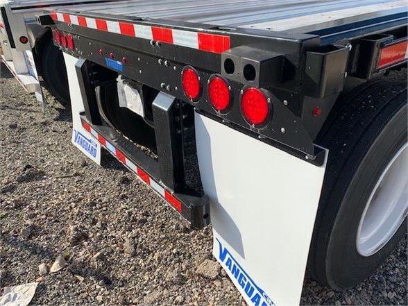 Vanguard 48ft steel flatbed trailer rear view showing taillights and white mudflaps with Vanguard logos.