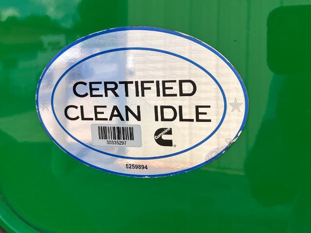 Sticker reading CERTIFIED CLEAN IDLE on green truck door with Cummins logo and barcode.