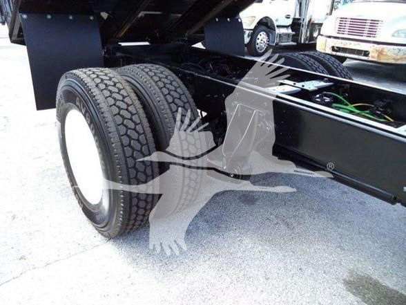 Dual rear tires on a truck chassis with grounding wires and frame sections visible. Text: VIN plate area not clearly readable.