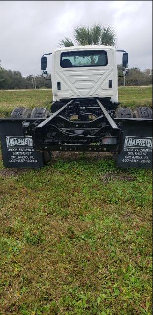 Cab and chassis truck rear view with dual rear axles and mud flaps showing 'MARTIN TRUCK EQUIPMENT' contact info.