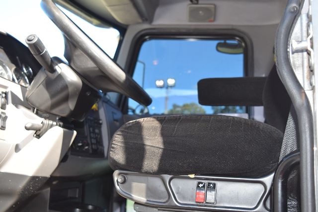 Peterbilt truck cab interior showing driver seat and dashboard controls.
