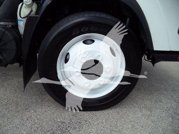 Chevrolet W4500 truck front wheel assembly showing Goodyear tire and white steel wheel. Visible text includes Goodyear on tire sidewall.