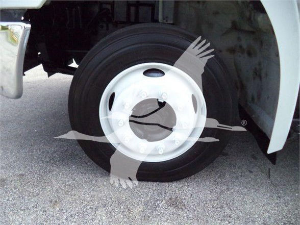 Truck wheel and fender showing front wheel with black tire and white steel rim; partial undercarriage and hub area visible.