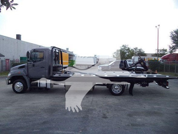 2014 Hino 258ALP tow truck with flatbed, side view showing cab and long bed.