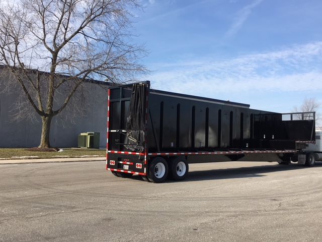 2002 Great Dane SINGLE DROP trailer in a street, black cargo bed with white wheels, long flatbed with drop sides, used crush car carrier.