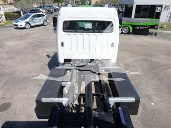 Rear view of a Freightliner M2 chassis showing a hydraulic tow apparatus with black rectangular components and metal brackets.