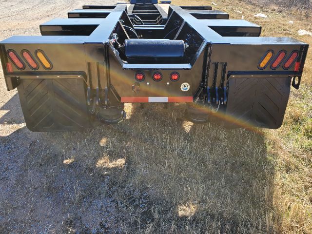 Atoka RGN-553-E lowboy trailer rear view showing taillights, fenders, and connection area with hoses and lights.